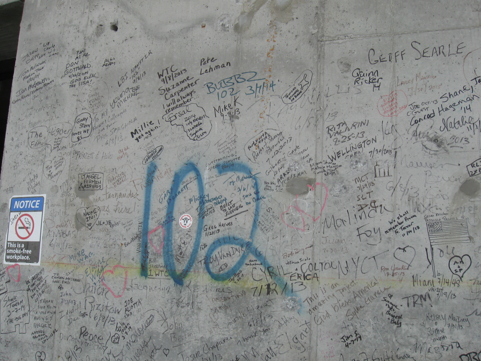 graffiti on the concrete wall at the world trade center, before it was covered up by wood panels. there are thousands of inscriptions. some are patriotic, some are poignant. many just have the name of a worker and a date. one says, i will always remember.